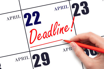 Hand drawing red line and writing the text Deadline on calendar date April 22. Deadline word...