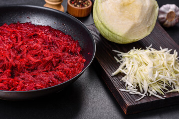 Chopped beetroot in a pan as well as spices and herbs on a wooden cutting board