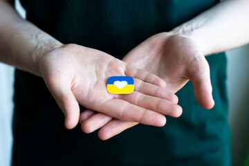 Support for Ukraine in the war with Russia. A young man holds a stylized flag of Ukraine. Conceptual photo.