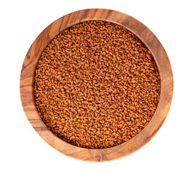 Camelina sativa seeds in olive bowl, isolated on white background. Seeds of camelina or false flax. Raw material for camelina oil. Top view.