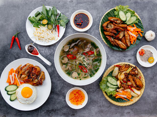 Beef Pho, Grilled Chicken, Deep Fried Pig Intestine, salad served in bowl isolated on dark grey background top view of japanese food