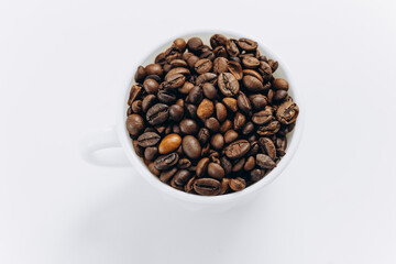 Coffee beans in white cup on white background