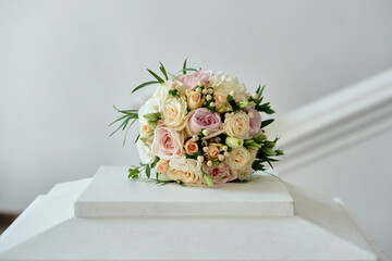 Close up of bridal bouquet of pink and white peony roses and greenery on white outdoors, copy...