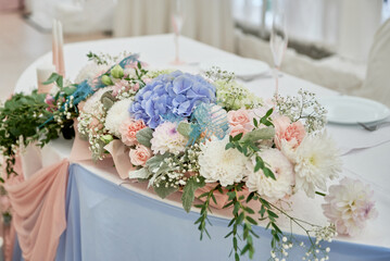 Beautiful floral arrangement of white flowers and greenery on wedding table in restaurant, copy...