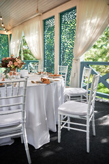 Table setting with sparkling wineglasses, plate with brown napkin and cutlery on table outdoors, copy space. Place set at wedding reception. Table served for wedding banquet in restaurant