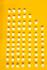 White sugar cubes arranged in diagonal lines on yellow background