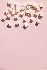 Refined sugar on pink background.Cubes of sweet and white sugar