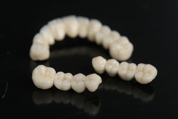 Dental ceramic bridge on isolated wite background. Metal free ceramic dental crowns.  Closeup ceramic to dental implants in laboratory.