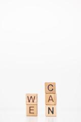 We can word is written on wooden cubes on a white background. Closeup of wooden elements