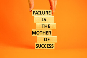 Failure or success symbol. Wooden blocks with words A failure is the mother of success. Beautiful orange table orange background. Businessman hand. Business, failure or success concept. Copy space.