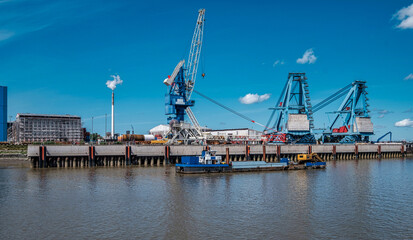 Obraz premium Anlegekai mit großen Krananlagen für Industrieanlagen und Boot mit Bagger