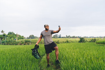 African American man using go pro camera for shooting influence vlog during travel journey in...