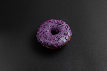 Blueberry Donut Sweet Snack Isolated on Black Background. Donut or Doughnut is a Fried Dough...