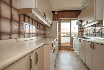 Apartment kitchen with beige furniture with matching stoneware floors and access to a terrace