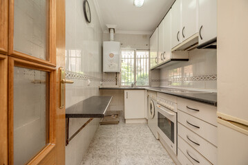 White wooden furniture kitchen with doors and drawers, white appliances and black countertop