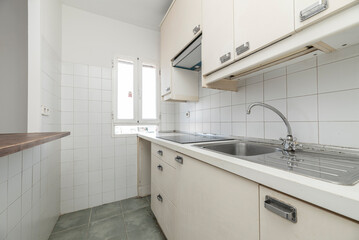 kitchen with white cabinets matching wood countertop serving hatch to the side and white square tiles