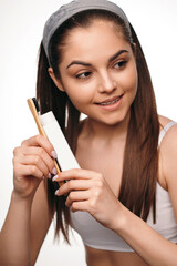 Woman with healthy white teeth holding toothbrush and paste