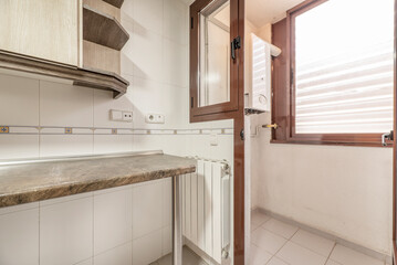 Kitchen corner with wooden worktop, white aluminum radiator, red aluminum and glass doors and windows
