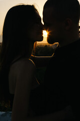 Silhouette of a loving couple kissing at sunset