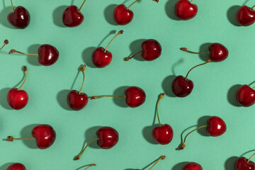 Sweet red cherries on a turquoise background. Top view.