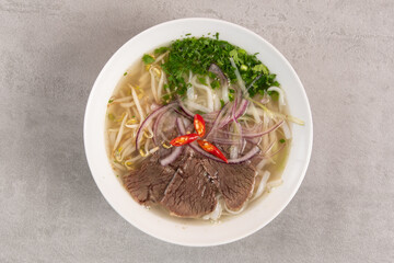 Pho Bo vietnamese Soup with beef on grey background