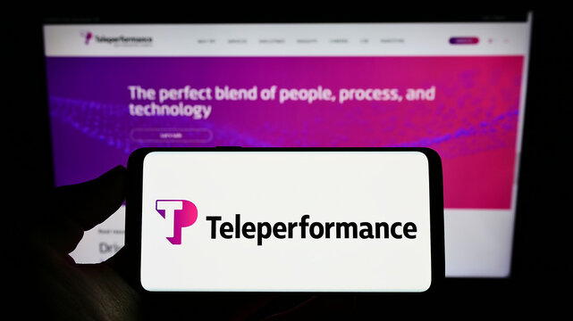 Stuttgart, Germany - 05-21-2022: Person holding cellphone with logo of French outsourcing company Teleperformance SE on screen in front of webpage. Focus on phone display.