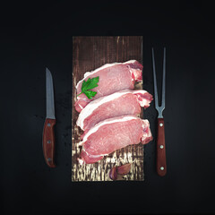 Raw veal meat fillet on kitchen cutting board with ingredients for cooking, knife and meat fork on dark background - obrazy, fototapety, plakaty