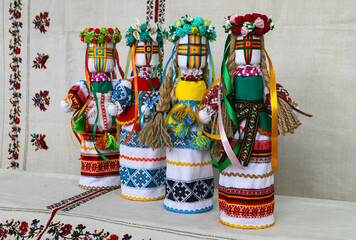 Traditional Ukrainian folk dolls motanka, handmade doll in folk costume, against the background of home-woven embroidered canvas. Culture of Ukraine, folk crafts