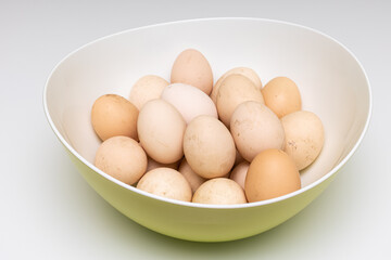 fresh unwashed rustic eggs lie in a deep bowl