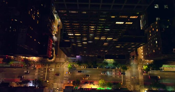 Flyover the well-lit streets of New York with lively traffic at night. Bird's eye perspective on the vibrant metropolis.