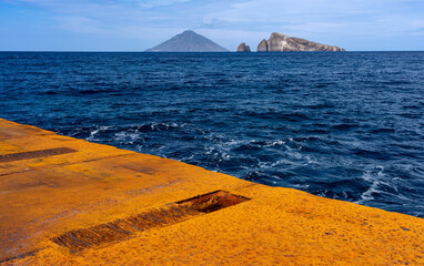 Liparische Inseln, die besondere Insel PANAREA: der Hafen mit rostigem Kai und dem blauen Meer, im...