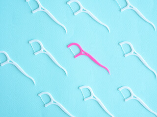 Dental floss pattern with plastic toothpick white and pink on blue. Dental concept