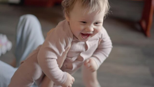 Happy carefree mother and cute small child daughter tickling laughing having fun lying on sofa and playing, smiling mum enjoying bonding cuddling hugging spending time with little funny kid at home