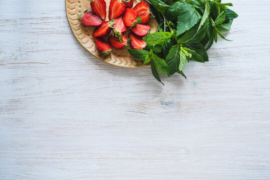 Fresh organic local herb and berry fruit. Sliced strawberries and mint