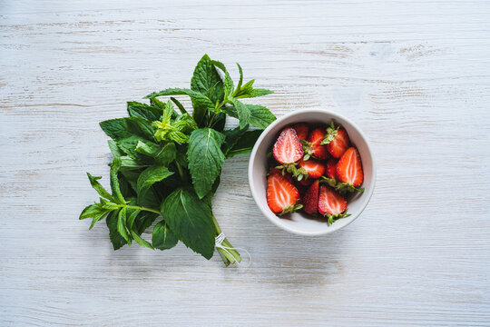 Fresh organic local herb and berry fruit. Sliced strawberries and mint