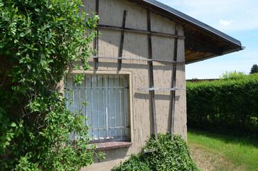 Fototapeta na wymiar Kleines altes Gartenhaus mit vergittertem Fenster