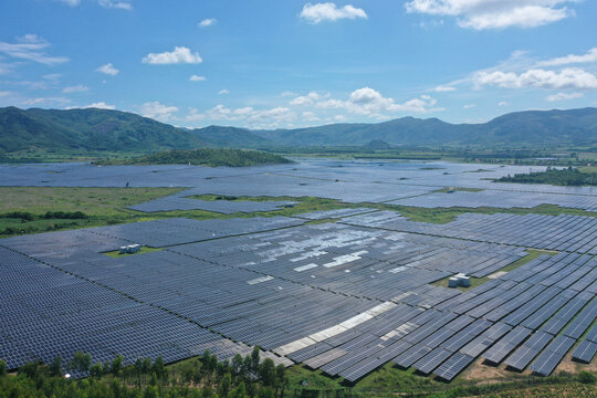 Aerial view of Ecology solar power station panels in the fields green energy in sunny day, landscape electrical innovation nature environment. Stock image surface of blue photovoltaic solar panels