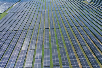 Aerial view of Ecology solar power station panels in the fields green energy in sunny day, landscape electrical innovation nature environment. Stock image surface of blue photovoltaic solar panels