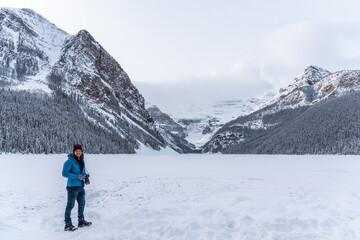 Fototapeta na wymiar Tourist taking photos in winter season at Lake Louise, Alberta, Canada. 