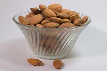 heap of Almonds in a glass bowl, white background
