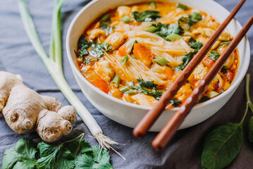 Thai red curry noodle soup with chicken in a bowl