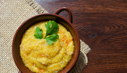 Corn porridge with cracklings, carrots and onions and herbs.