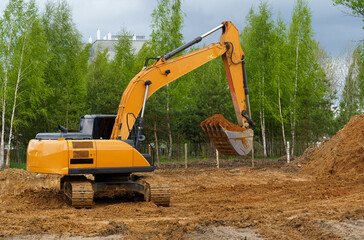 An excavator is digging a pit for a house.