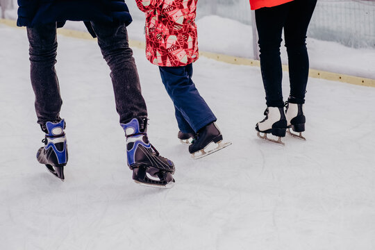 Skates On Legs Close Up. Happy Family Spending Time Together At Outdoor Ice Skating Rink