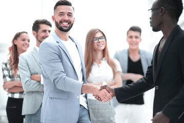 Business team of several people, mens shaking hands and smiling.