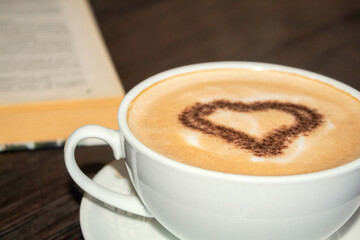 Coffee up close. Heart in coffee. Coffee with a book