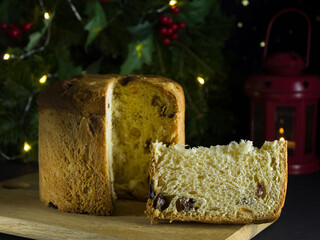 A piece of panettone next to a cake on a wooden board. Traditional Italian Christmas pastries