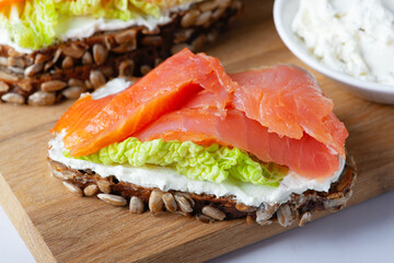 Healthy toasts with rye bread with cream cheese, salmon and salad