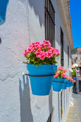 Fototapeta na wymiar Flower pots attached as decor to the walls of houses. The famous decor of Andalusia.