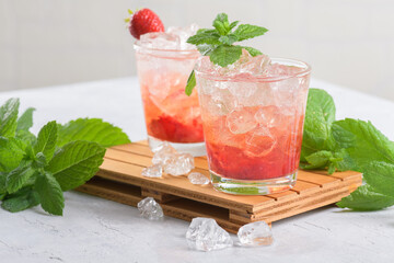Cold summer strawberry cocktail mojito, margarita, daiquiri. Two glasses with fresh strawberry soda...